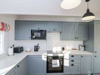 A kitchen with cabinets, microwave, kettle, and toaster at Croft View Fylingthorpe near Robin Hood's Bay