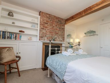 A bedroom with a bed and shelving at Croft View in Fylingthorpe near Robin Hood's Bay