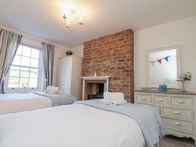 A bedroom with two beds and a fireplace at Croft View in Fylingthorpe near Robin Hood's Bay