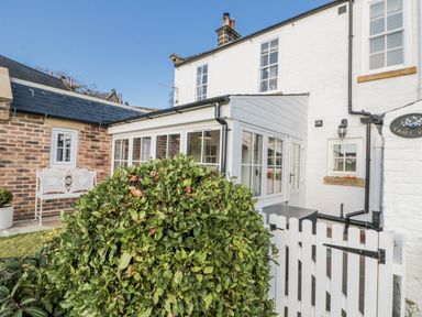 An outdoor area with a conservatory and seating at Croft View in Fylingthorpe near Robin Hood's Bay