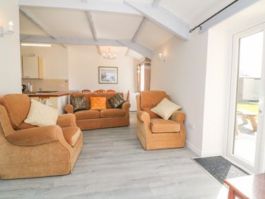 A living room with two armchairs and a sofa with cushions at The Cottage in Chilsworthy near Holsworthy