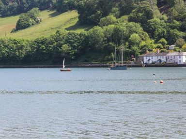 A body of water with sailboats and houses near a forested hillside at Ancarva Near Kingsands