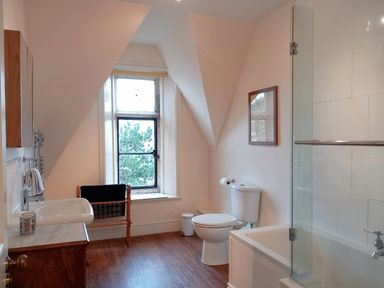 A bathroom with a toilet sink bathtub and window with towel rack at Haslington House in Malvern