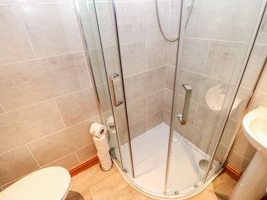 A bathroom with a corner shower enclosure a toilet and a pedestal sink at The Hayloft in Milton near Brampton