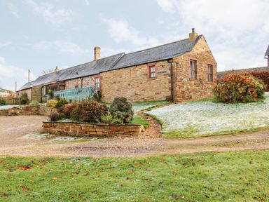 A stone house with a garden and a gravel pathway at The Hayloft in Milton near Brampton