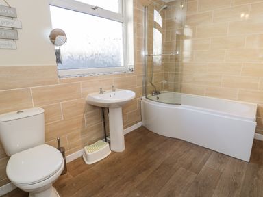 A bathroom with a toilet sink bathtub and a window at Tryfan in Llanberis