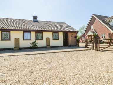 A single story house with tiled roof and three windows beside a gravel driveway at Kingfisher in Wattisfield near Rickinghall and Diss
