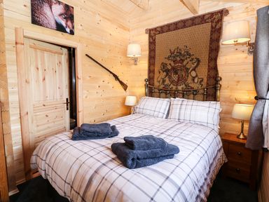 A bedroom with a double bed and folded towels on it at The Shooting Lodge in Longnor