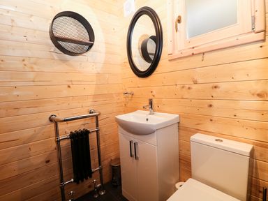 A bathroom with a sink cabinet mirror window towel heater and toilet at The Shooting Lodge in Longnor
