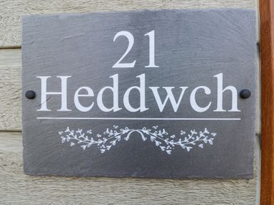 A house number plaque with the number 21 and the name Heddwch