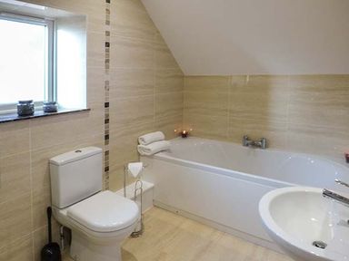 A bathroom with a toilet bathtub sink and window at Rose Cottage in Winforton near Hay-on-Wye