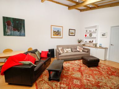 A living room with sofas, a coffee table, round dining table, and paintings on the wall at View The Gallery in Okehampton
