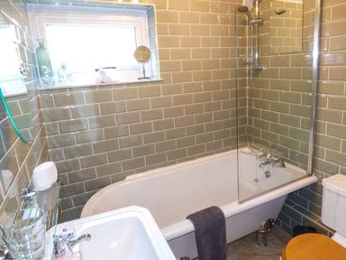 A bathroom with a bathtub shower sink and toilet at Kitts Cottage in Little Malvern near Malvern
