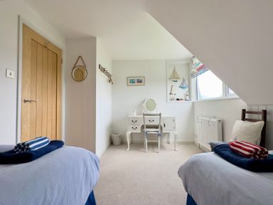 A bedroom with two beds and a desk at Kilcarreg in Rock near Wadebridge