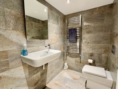 A bathroom with a sink, toilet, and towel rail at Kilcarreg in Rock near Wadebridge