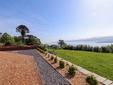 A garden with a gravel path lawn and sea view at Menai View near Menai Bridge