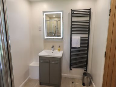 A bathroom with a sink and mirror at Yew - Woodland Cottages in Bowness-On-Windermere