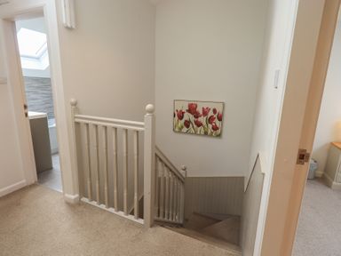 A staircase with wall art and a door at Yew - Woodland Cottages in Bowness-On-Windermere