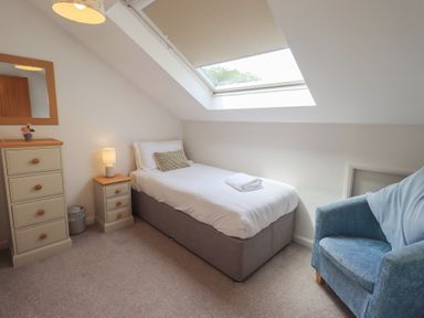 A bedroom with a single bed and bedside table at Yew - Woodland Cottages Bowness-On-Windermere