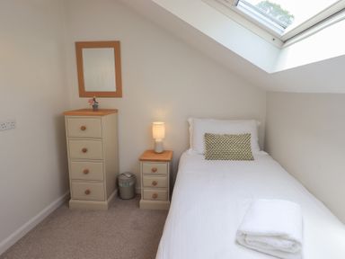 A bedroom with a single bed and dresser at Yew - Woodland Cottages Bowness-On-Windermere