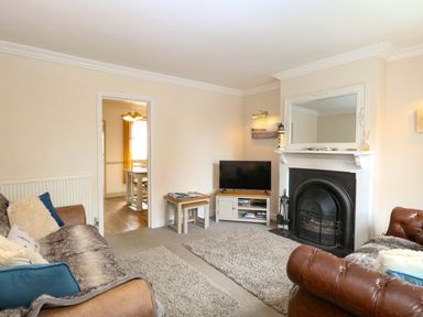 A living room with sofas and a television at Fern Cottage in Heacham