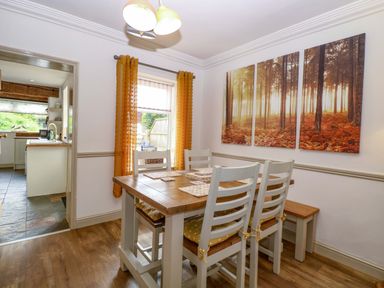 A dining room with a table and chairs at Fern Cottage in Heacham