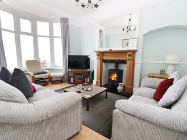 A living room with two sofas a wooden coffee table a fireplace a television and an armchair at Number Fifteen in Withernsea
