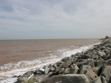 A rocky shoreline with waves and a cloudy sky at Number Fifteen in Withernsea