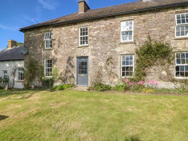 Stone house exterior with blue door and multiple windows and garden in front at Ballintlea Ballintlea near Dungarvan County Waterford