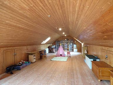 A long attic room with wooden walls and ceiling with shelves and a pink play tent in the center at The Sanctuary in Killavullen near Mallow