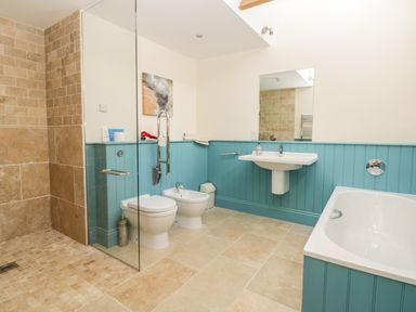 A bathroom with a walk in shower toilet bidet sink and bathtub at Cow Byre in Malton