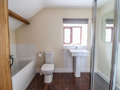 A bathroom with a bathtub toilet sink and shower enclosure at Beudy Bach Barn in Llanuwchllyn near Bala
