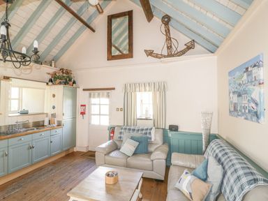 A living room with a sofa and coffee table at Dovecote in Gorran Haven