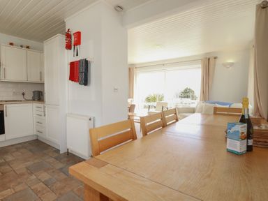 A dining room with a table and chairs at Treverrion in Gorran Haven