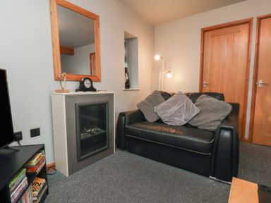 A living room with a sofa and a mirror at Fortunatus in Whitby