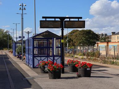 A bus stop with flower pots and a display board at Snowdrop in Saltburn-by-the-Sea