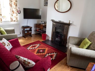 A living room with two armchairs a sofa a rug and a fireplace at Anvil Lodge in Goulceby near Louth