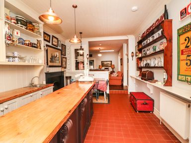 A kitchen with wooden countertop and shelves with dishes and vintage decorations at The Merchant's Store Kilrush Country Clare