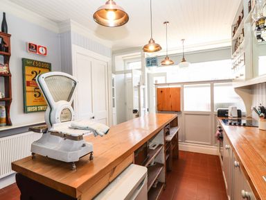 A kitchen with a wooden island and vintage scale on top at The Merchant's Store in Kilrush Country Clare