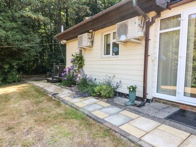 A garden path with flowers along the side of a house at Badger View in Culverstone Green near Chatham