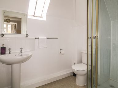 A bathroom with a sink mirror towel rail toilet and a shower cubicle at Aldrich Cottage in Radstock