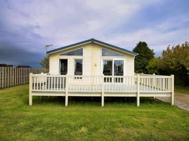A house with a deck and fenced yard at Cheri in Southerness