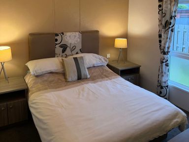 A bedroom with a bed and lamps at Cheri in Southerness