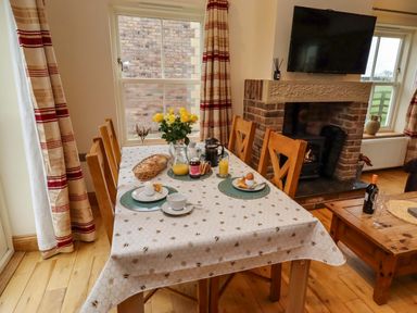 A dining room with a table set for breakfast at West Gate in Embleton