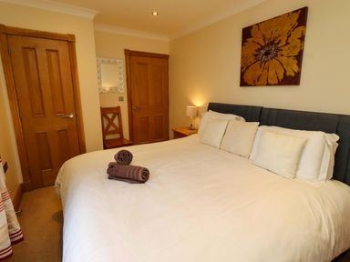 A bedroom with a bed and bedside lamp at West Gate in Embleton