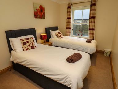A bedroom with two twin beds and a window at West Gate in Embleton