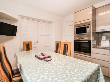 A dining table with chairs and a microwave oven in a kitchen at Rothay 17 in Ambleside