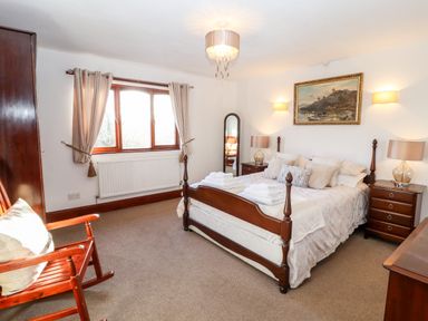 A bedroom with a wooden bed and bedside tables with lamps at Green Hills Farm in Ulverston
