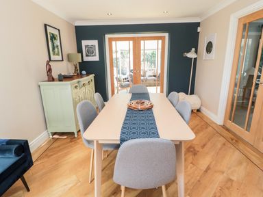A dining room with a wooden table and gray chairs at The Croft in Longhoughton near Alnwick