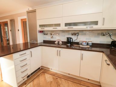 A kitchen with cream cabinets brown countertops a kettle toaster and storage jars at The Croft in Longhoughton near Alnwick